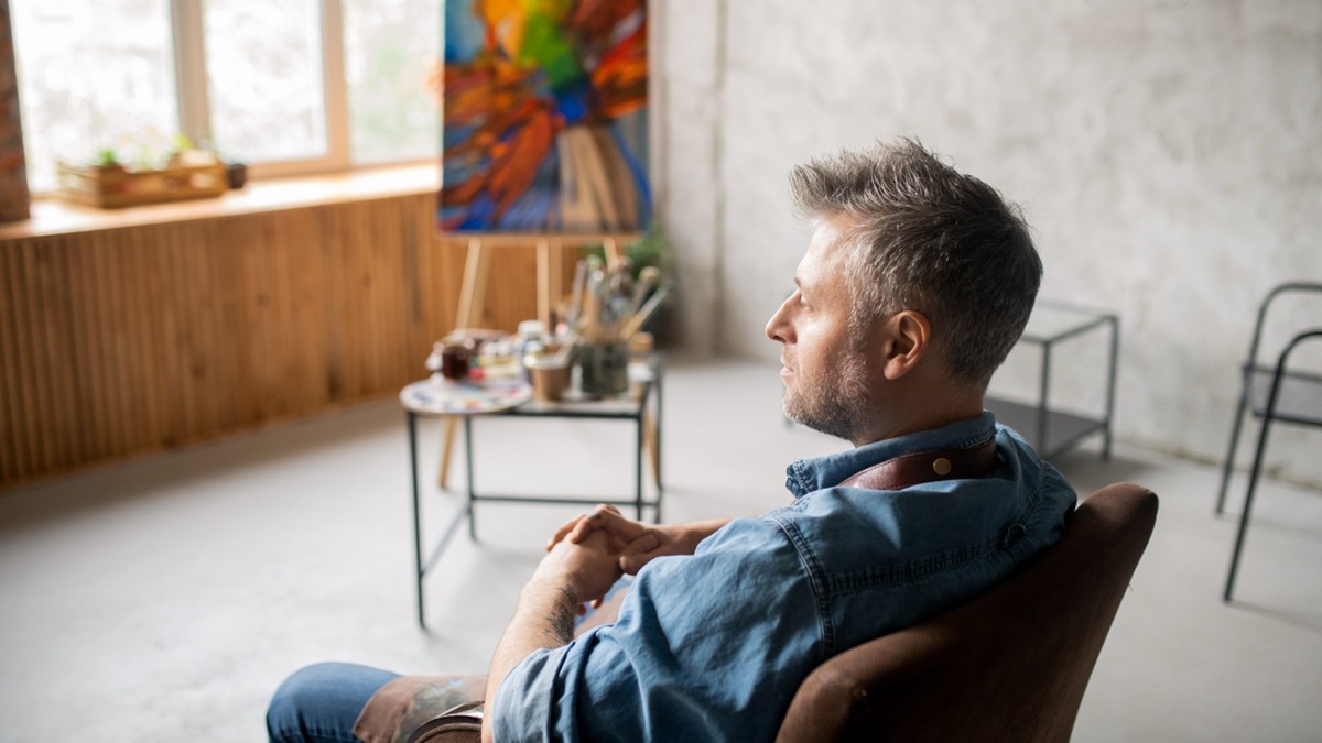 Adulte seul dans un intérieur calme, traduisant l’hypervigilance et la fatigue émotionnelle après un choc.