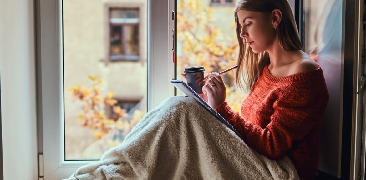 Personne assise près d’une fenêtre dans une ambiance douce, illustrant la reconstruction après un traumatisme.