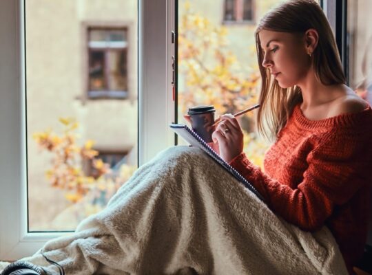 Personne assise près d’une fenêtre dans une ambiance douce, illustrant la reconstruction après un traumatisme.